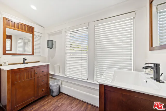 a bathroom with a granite countertop sink mirror and a large window