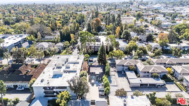 a front view of a building with a garden and plants