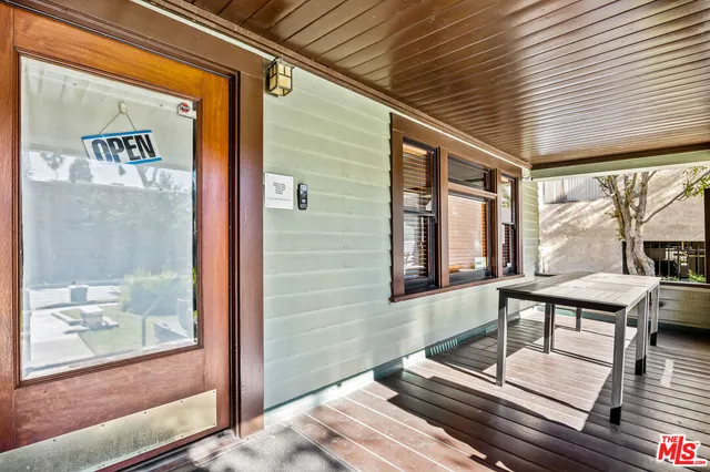 a roof deck with wooden floor and furniture