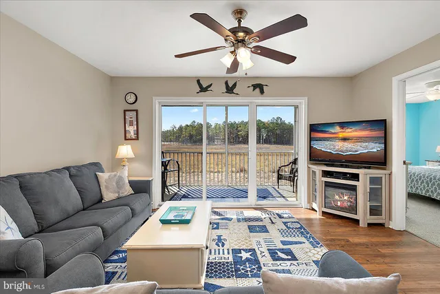 a living room with furniture a flat screen tv and floor to ceiling window