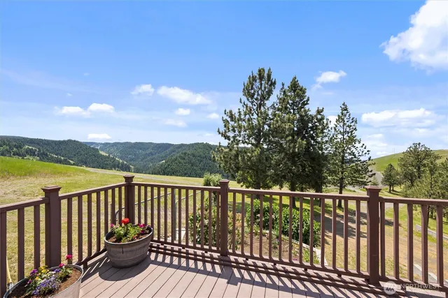 a view of a balcony with wooden floor & fence