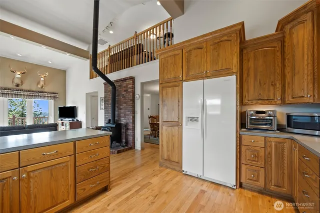 a kitchen with stainless steel appliances granite countertop a refrigerator a stove and a sink with cabinets