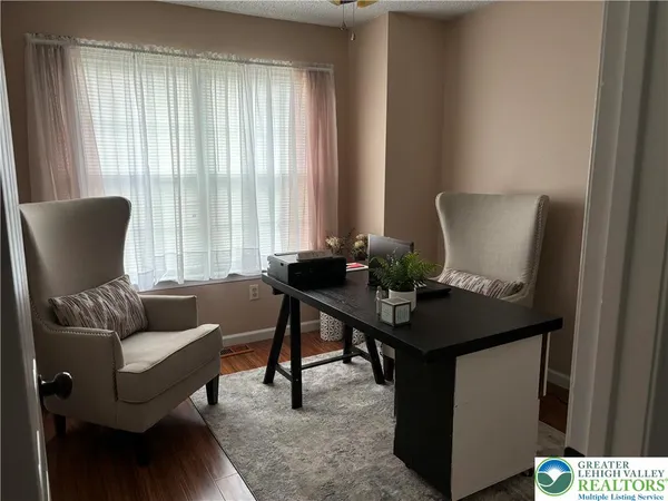 a view of a workspace with furniture and a window