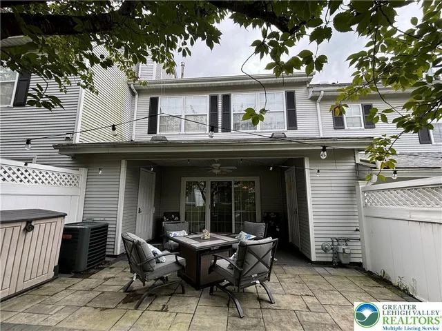 a view of house with patio outdoor seating and covered with trees