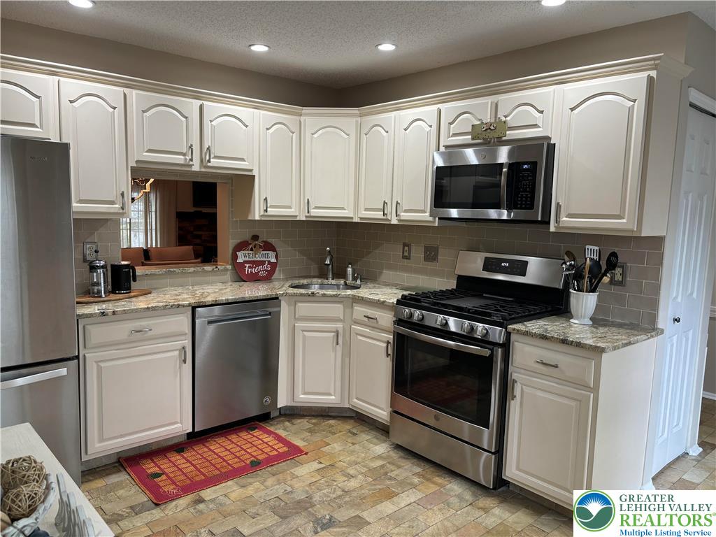 1963 Delancey Street Hellertown, PA 18055 - Photo 2 of 26 a kitchen with stainless steel appliances granite countertop a sink dishwasher a stove and a microwave oven with cabinets