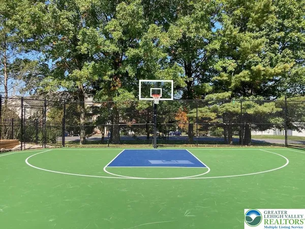 a view of a tennis ground with large trees