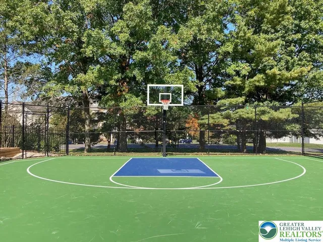 a view of a tennis ground with large trees