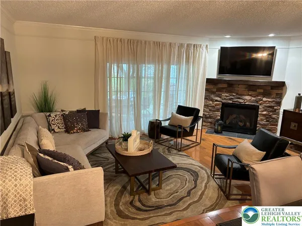 a living room with furniture a fireplace and a flat screen tv