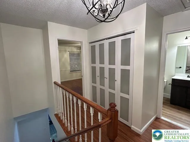 a view of staircase with railing and a chandelier
