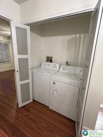 a utility room with wooden floor washer and dryer