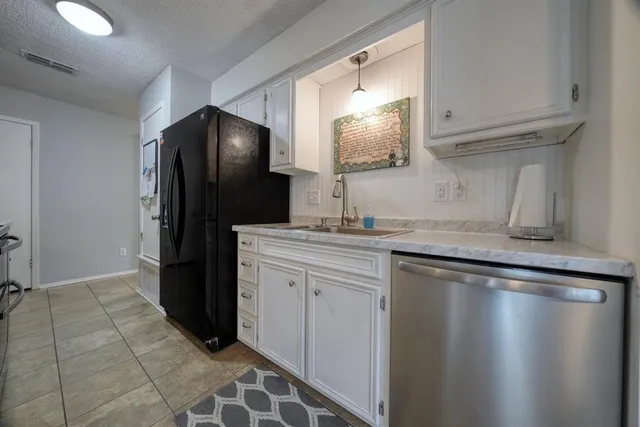 a kitchen with stainless steel appliances granite countertop a refrigerator and a sink