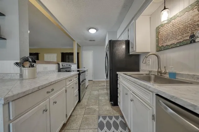 a kitchen with stainless steel appliances granite countertop a sink and refrigerator