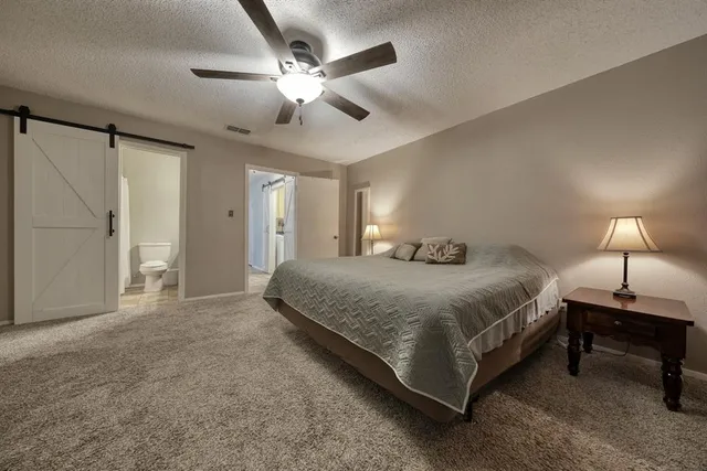a spacious bedroom with a bed and a chandelier