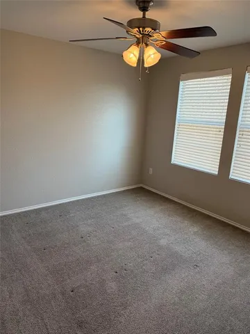 an empty room with a window and a fan
