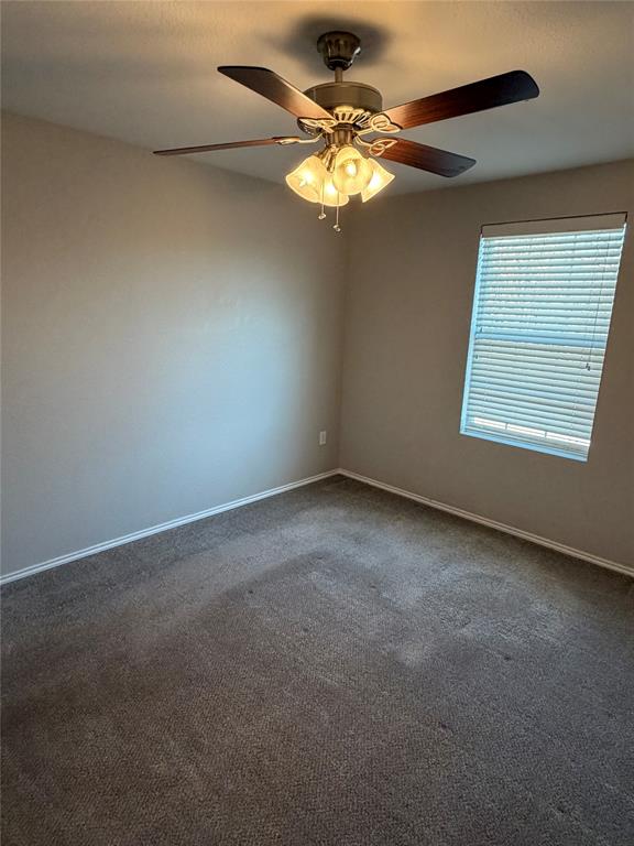 3604 Monte Verde Way Denton, TX 76208 - Photo 15 of 24 an empty room with a chandelier fan and windows