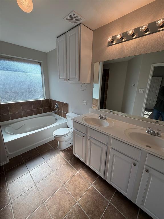 3604 Monte Verde Way Denton, TX 76208 - Photo 22 of 24 a bathroom with a granite countertop sink a toilet and bathtub