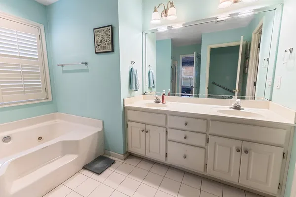 a bathroom with a tub sink and mirror