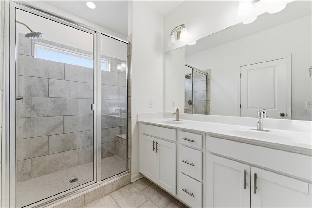 1621 Avery Way Tucker, GA 30084 - Photo 25 of 29 a bathroom with a double vanity sink mirror and shower