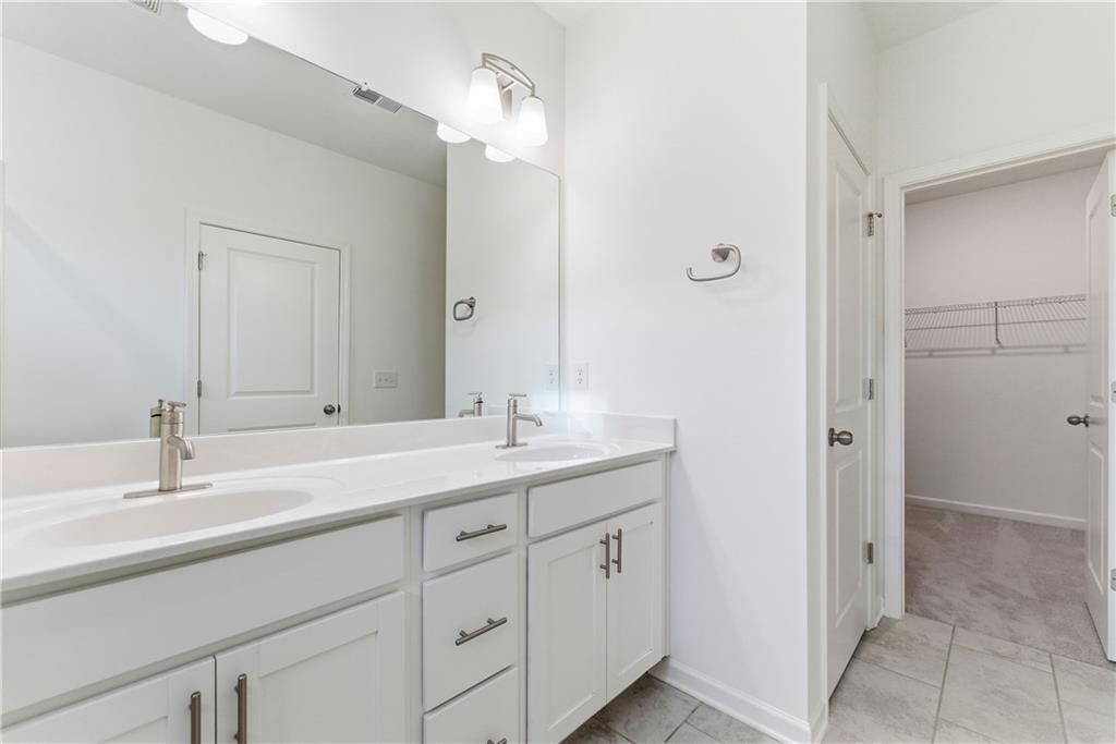 1621 Avery Way Tucker, GA 30084 - Photo 26 of 29 a bathroom with a double vanity sink and mirror