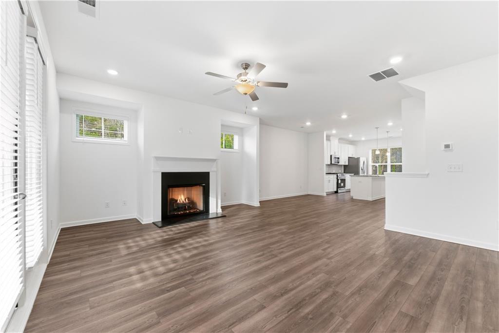 1621 Avery Way Tucker, GA 30084 - Photo 10 of 29 a view of a livingroom with a fireplace a ceiling fan and kitchen view