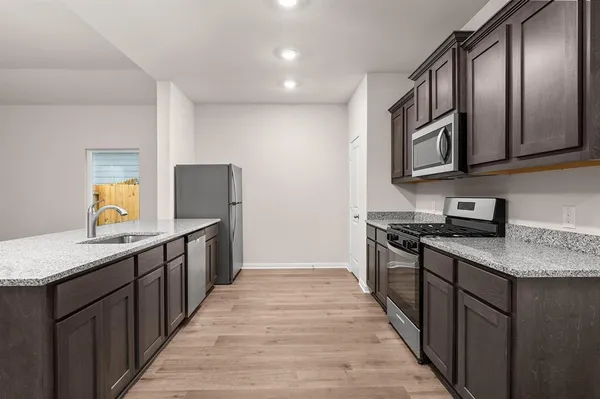 a kitchen with stainless steel appliances granite countertop a stove a sink and a refrigerator