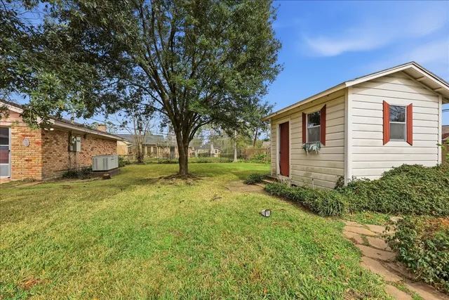 a view of a house with backyard and trees