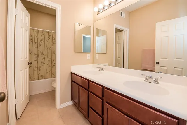 a bathroom with a double vanity sink mirror and shower