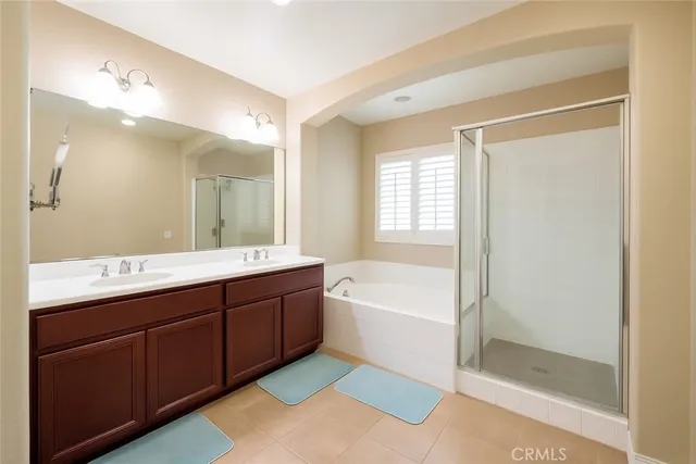 a spacious bathroom with a tub sink shower and mirror