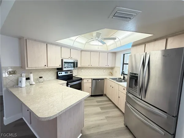 a kitchen with a sink stainless steel appliances and white cabinets
