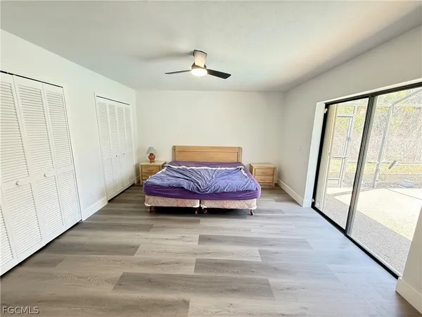 a spacious bedroom with a bed and wooden floor
