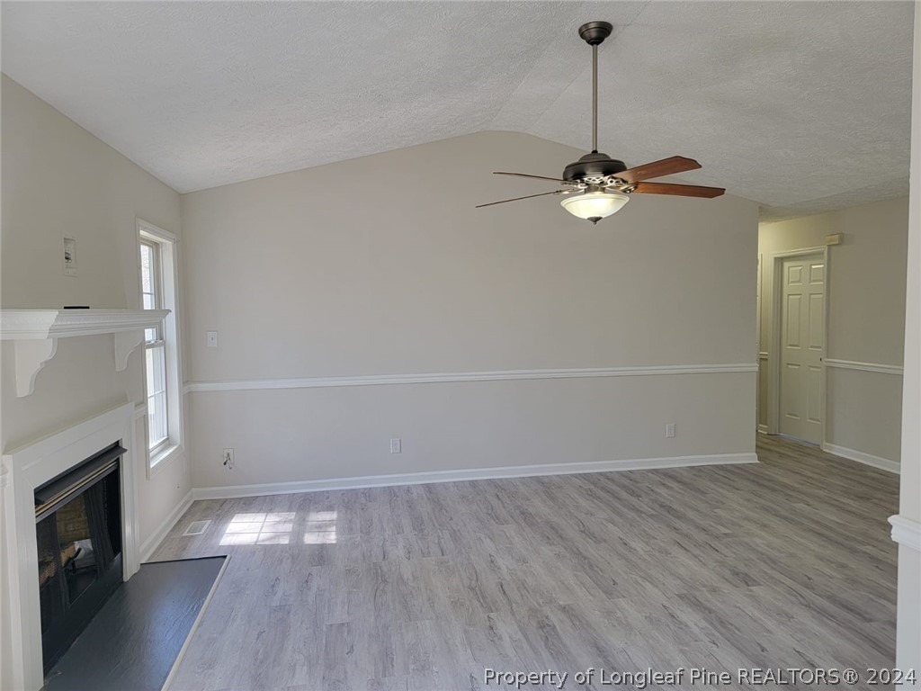 191 Rye Lane Raeford, NC 28376 - Photo 15 of 44 wooden floor in an empty room with a fireplace