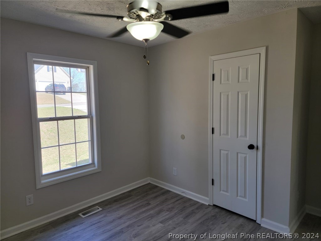 191 Rye Lane Raeford, NC 28376 - Photo 35 of 44 an empty room with wooden floor chandelier fan and windows