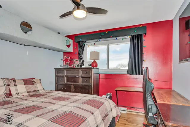 a bedroom with a bed a chandelier and dresser