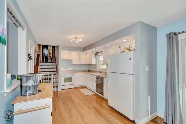 a kitchen with white cabinets and white appliances