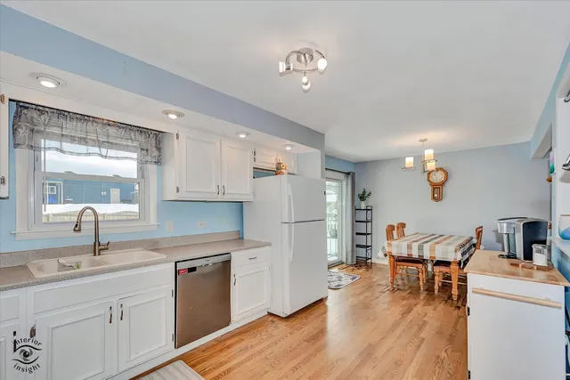 a kitchen that has a lot of cabinets a sink and appliances in it