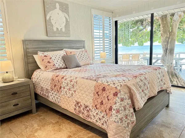 a large bed sitting in a bedroom next to a window