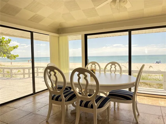 a view of a dining room with furniture water view and wooden floor