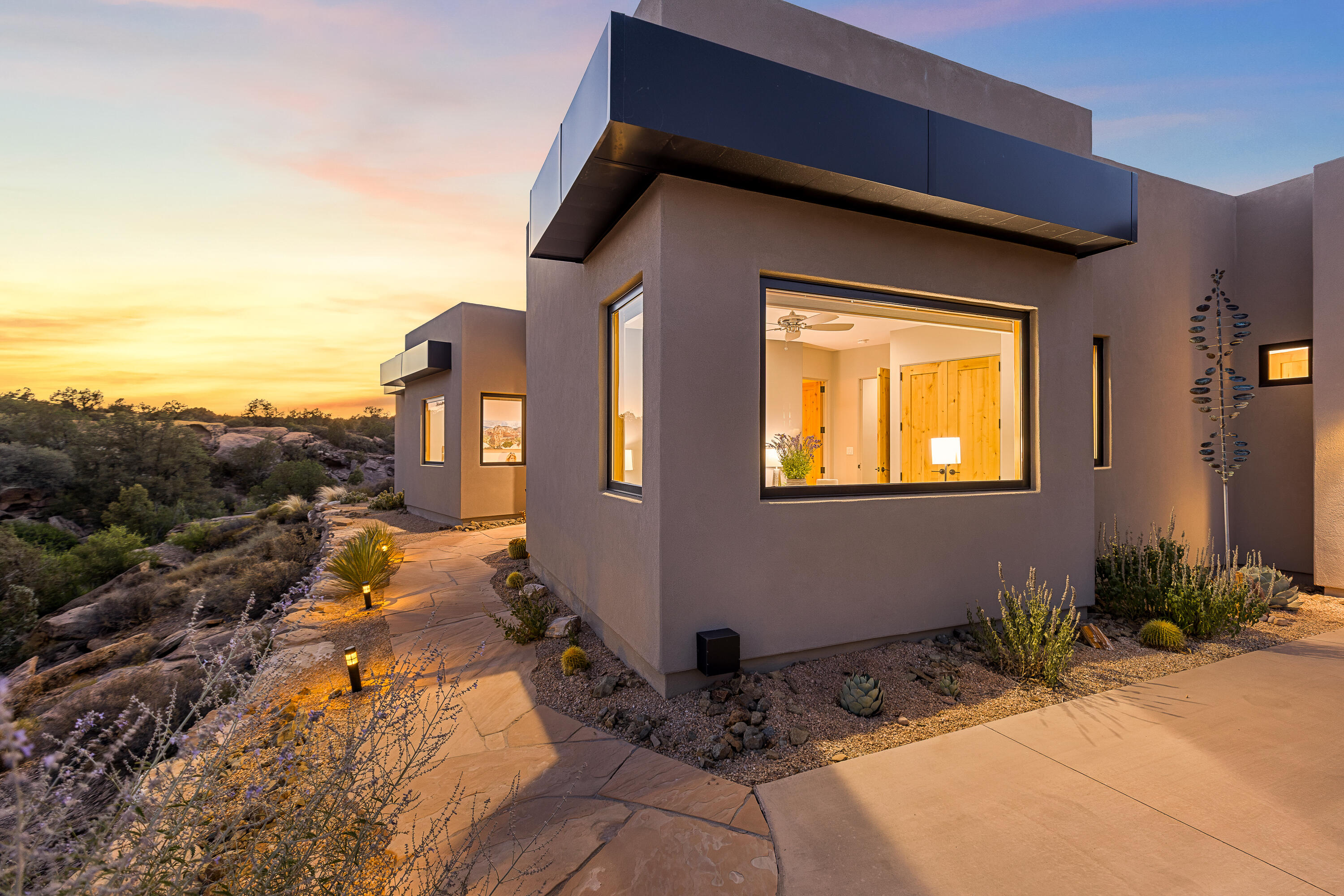 3000 Navajo Way Springdale, UT 84767 - Photo 14 of 63 Corner elevation at twilight showing the home's lit interior, desert landscaping, and low-profile architecture.