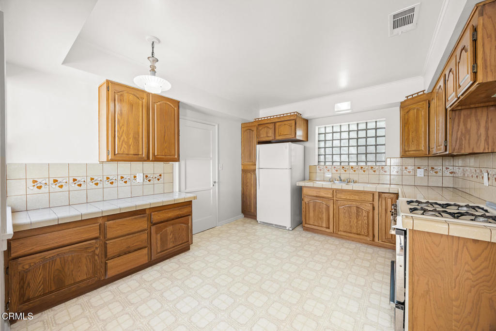 1519 Spruce Street South Pasadena, CA 91030 - Photo 3 of 5 a kitchen with a refrigerator a sink and cabinets