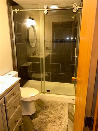 a bathroom with a shower toilet and sink
