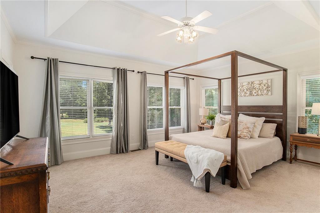 960 Providence Lane Monroe, GA 30656 - Photo 22 of 53 a spacious bedroom with a bed couch and a flat tv screen next to a window