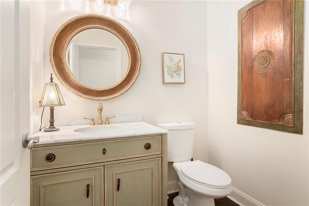 960 Providence Lane Monroe, GA 30656 - Photo 30 of 53 a bathroom with a granite countertop toilet a sink and a mirror
