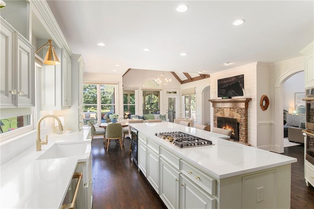 960 Providence Lane Monroe, GA 30656 - Photo 10 of 53 a kitchen with a stove a sink a kitchen island a dining table and chairs