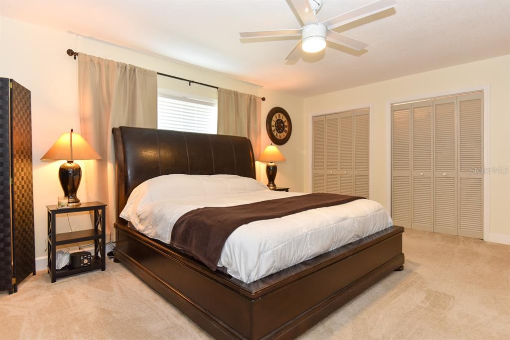 213 Riverbend Road Ormond Beach, FL 32174 - Photo 27 of 78 a bedroom with a bed and a chandelier