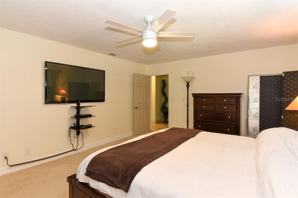 213 Riverbend Road Ormond Beach, FL 32174 - Photo 29 of 78 a bedroom with a bed and a flat tv screen on dresser