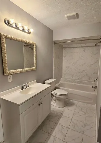 a bathroom with a toilet sink vanity and mirror