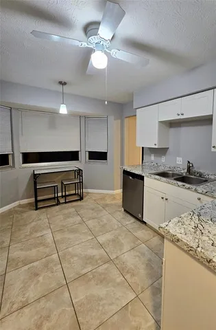 a kitchen with granite countertop a stove a sink and a refrigerator
