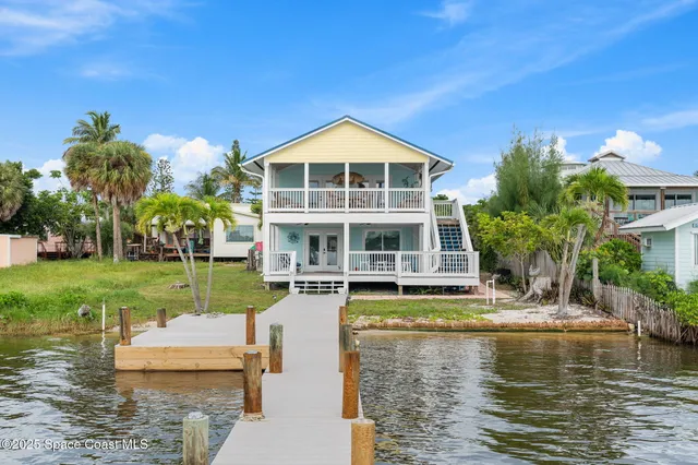 a view of a house with swimming pool lawn chairs and a yard