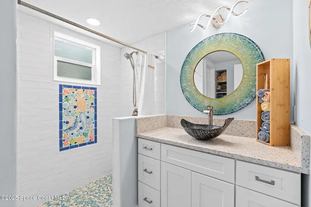 a bathroom with a granite countertop sink a mirror and vanity