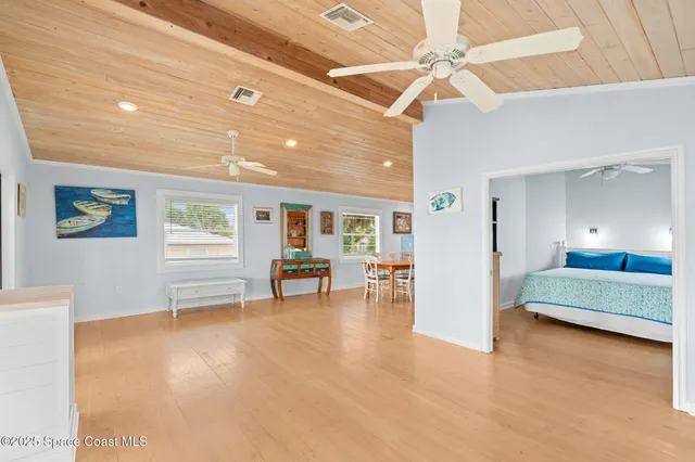 a view of an empty room with furniture and a ceiling fan